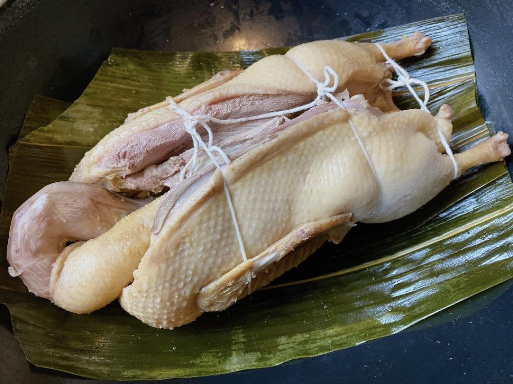 Prepare the Pot: Trim the ends off the softened bamboo leaves. Line the bottom of your empty, clean pot with them. Place the trussed duck directly on top of the leaves.