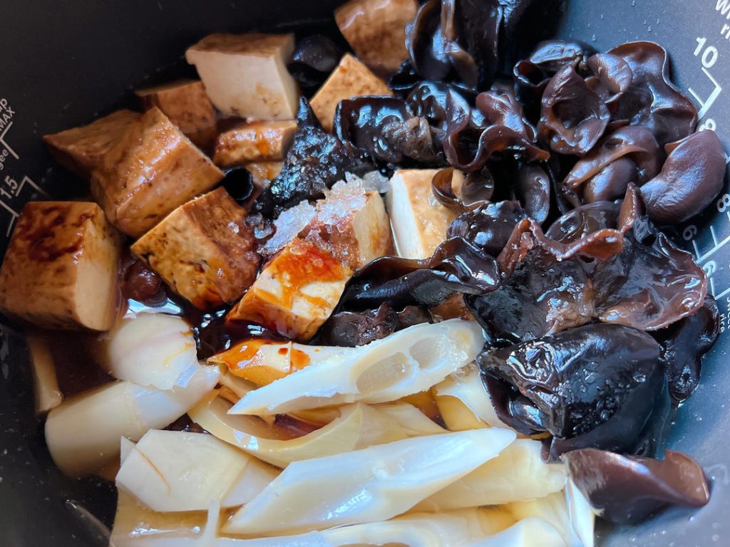 Season and Add Water: Pour in the remaining light soy sauce, dark soy sauce, Shaoxing wine, and sugar. Pour in fresh water until it reaches just below the top layer of ingredients. Visual cue: You should see the water, but the top ingredients should not be swimming.