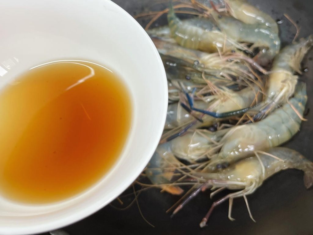 Pour the Shaoxing Rice Wine around the edges of the pan. Cover immediately with a lid.