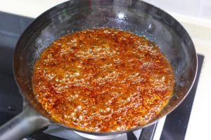 Pour the Chinese Black Vinegar (15g) along the edge of the pot. It will sizzle loudly—this is normal!