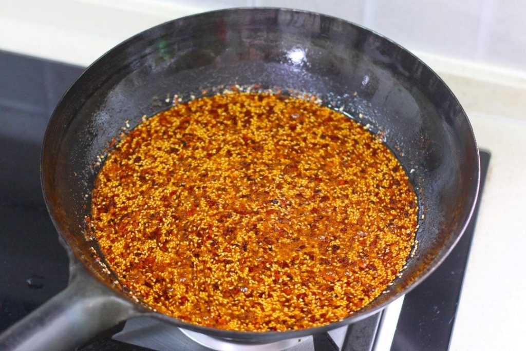 Transfer the oil (and the sludge of chilies at the bottom) into a heat-proof ceramic or stainless steel basin/jar. Cover with a lid immediately. Let it sit undisturbed for 24 hours (or at least overnight).