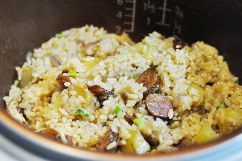 Cook and Serve Close the lid and press the "Cook" or "White Rice" button. Once the cycle is finished, let it sit on "Keep Warm" for 10 minutes to let the moisture redistribute. Open the lid, add chopped scallions, and fluff the rice gently with a paddle to mix the toppings throughout.