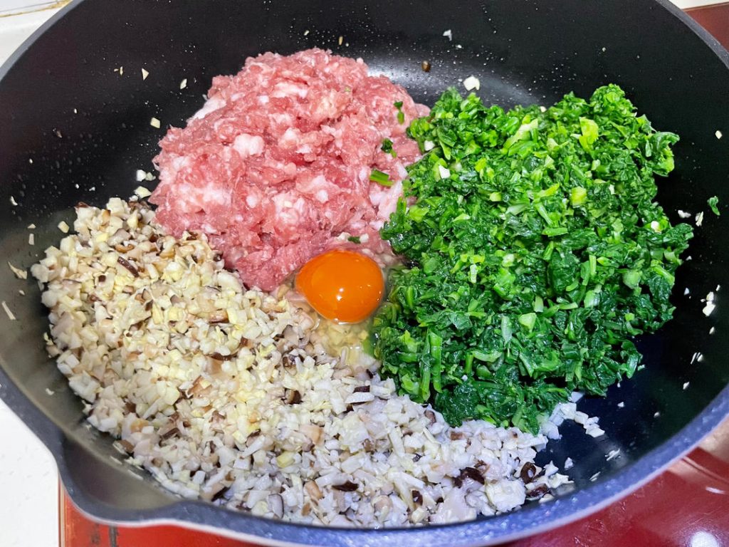 Mix the filling: In a large mixing bowl, combine the chopped greens, minced pork, and the cooled mushroom mixture. Add the egg, Shaoxing wine, salt, sugar, and seasoned oil.