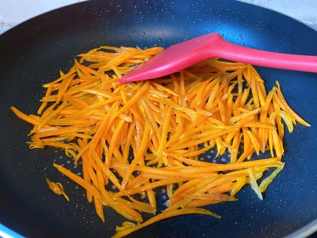 Fry the Carrots: Add the julienned carrots to the hot oil. Stir-fry for about 1 to 2 minutes. Why? Frying the carrots first softens their texture and infuses the oil with beta-carotene, turning the oil a beautiful golden hue.