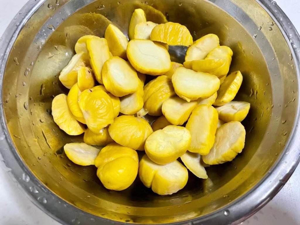 Meanwhile, prepare the chestnuts. If using fresh raw chestnuts, cut them in half. Bring a pot of lightly salted water to a boil. Boil the chestnuts for 2 minutes, then carefully peel off the hard shell and inner skin. Dice the peeled chestnuts.