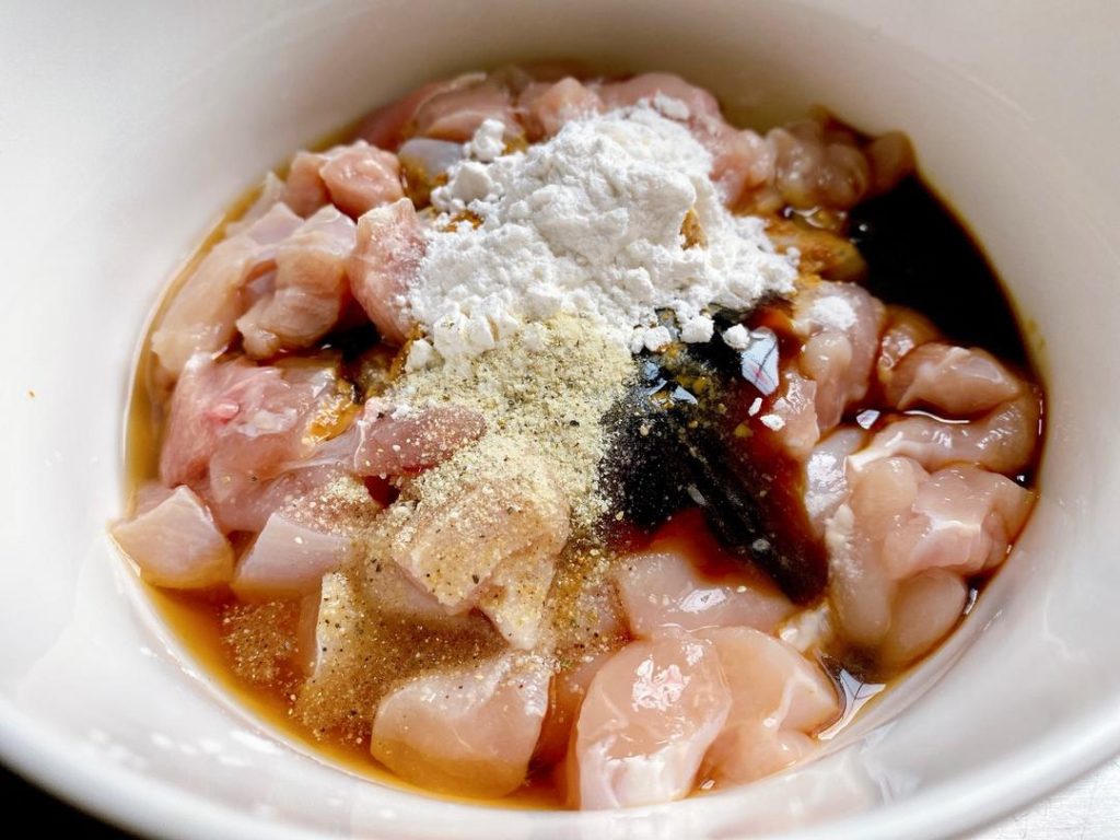 Meanwhile, mix the chicken with its marinade ingredients, including a splash of Shaoxing Wine. Massage the mixture with your hands until the liquid is fully absorbed. Let it rest for 15 minutes.