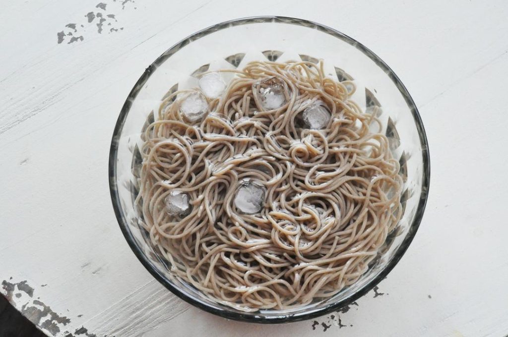 The Ice Shock (Crucial Step) Drain the noodles and immediately transfer them into your prepared ice water bath. Swish them around with your hands or tongs to wash off the excess surface starch.