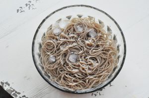 The Ice Shock (Crucial Step) Drain the noodles and immediately transfer them into your prepared ice water bath. Swish them around with your hands or tongs to wash off the excess surface starch.