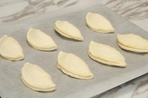Take a tart shell and flatten it slightly with your palm. Place a spoonful of the cooked durian paste in the center. Do not be greedy! Overfilling is the #1 cause of leakage.