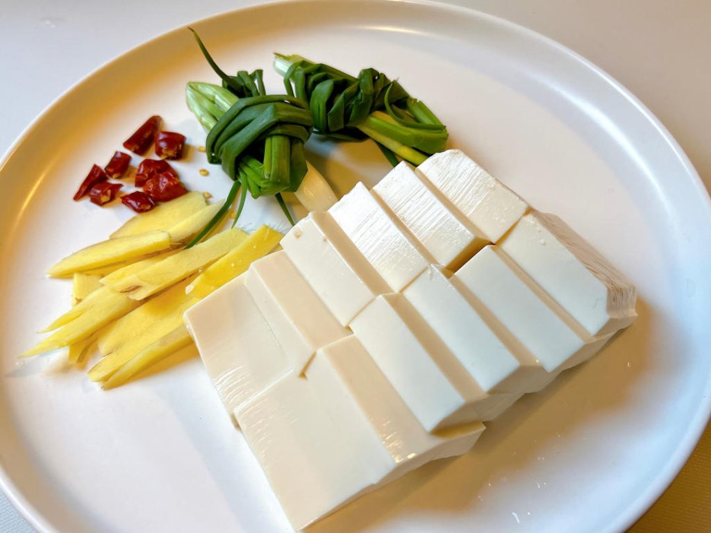 Cut the soft tofu into 1-inch (2.5 cm) cubes. Slice the ginger and prepare your scallion knots.