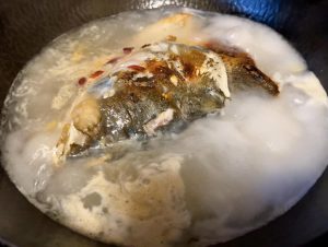 Emulsify the Broth Flip the fish head upright. Immediately pour the prepared boiling water directly into the wok. Turn the heat up to the highest setting. The water should erupt into a violent, rolling boil immediately.