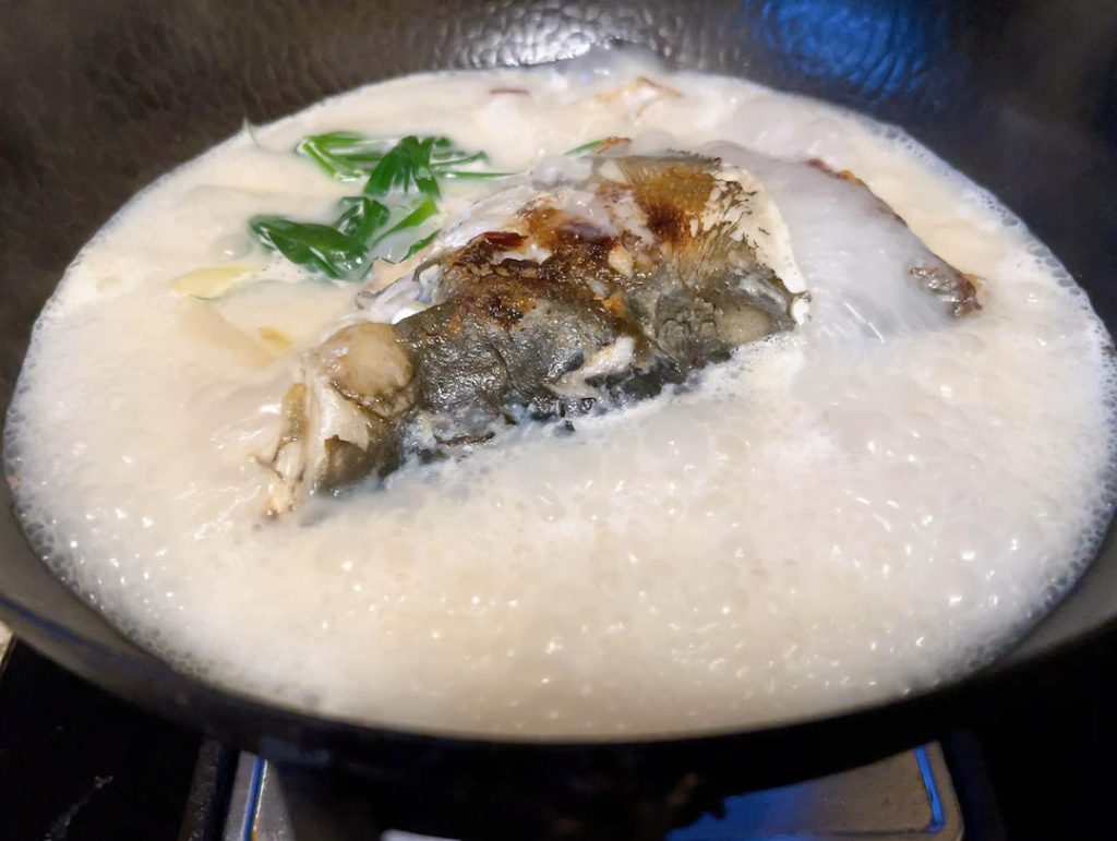 Skim and Thicken
Use a fine-mesh skimmer or a spoon to carefully remove any grey foam that floats to the surface. Drop in the scallion knots. Continue to boil on high heat for about 3 minutes. You will physically see the liquid transform into a rich, milky-white color as it thickens.