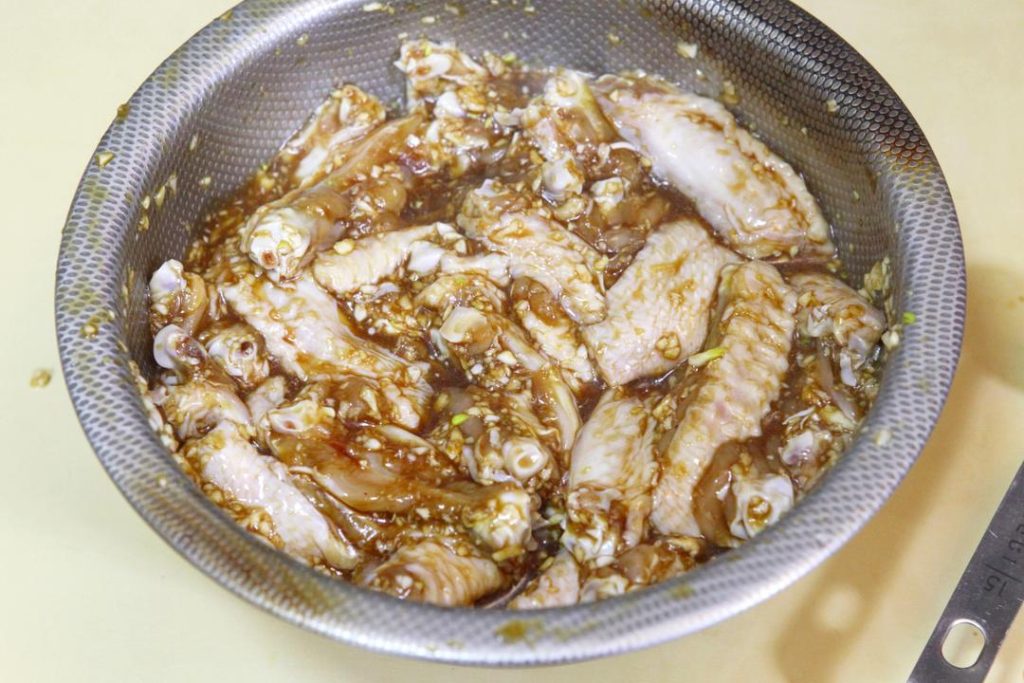 Marinate In a large bowl, combine the wings with the minced garlic, light soy sauce, dark soy sauce, Shaoxing wine, oyster sauce, salt, sugar, chicken essence, and white pepper. Mix by hand until well coated. Cover and marinate for 30 minutes.