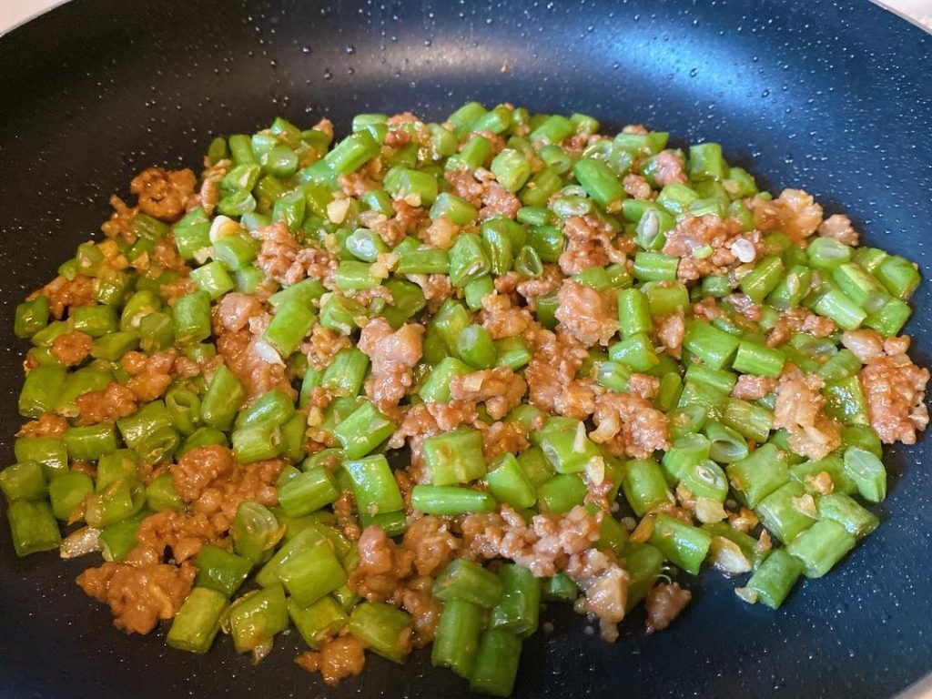 Finish the Dish: Stir-fry everything together for another 30 seconds so the flavors meld. Since the beans are already cooked, do not over-fry. Turn off the heat and plate immediately.