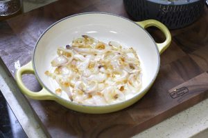 Create the Aromatic Bed Place your cast iron pot over medium heat. Add the neutral oil. Once the oil shimmers, add the smashed garlic and sliced onions. Sauté for 1-2 minutes until the onions are fragrant and slightly softened, but not browned. Spread them out evenly to cover the entire bottom of the pot.