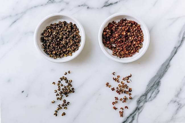 Close-up comparison of Green Sichuan Peppercorns vs Red Sichuan Peppercorns showing color and texture differences