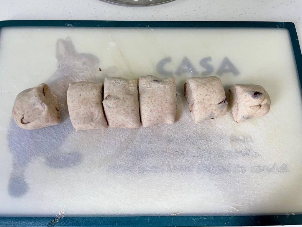 Cut: Use a sharp knife to cut the cylinder into 6 equal pieces. Place each piece onto a square of parchment paper.
