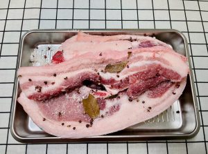 Once the salt mixture is cool, rub it thoroughly over every inch of the pork belly strips. Ensure you get into the crevices and coat the skin. Place the pork in a large bowl or container. Let it cure in a cool place (refrigerator is safest) for 3 to 4 days. Turn the meat once a day to redistribute the juices that will be drawn out.