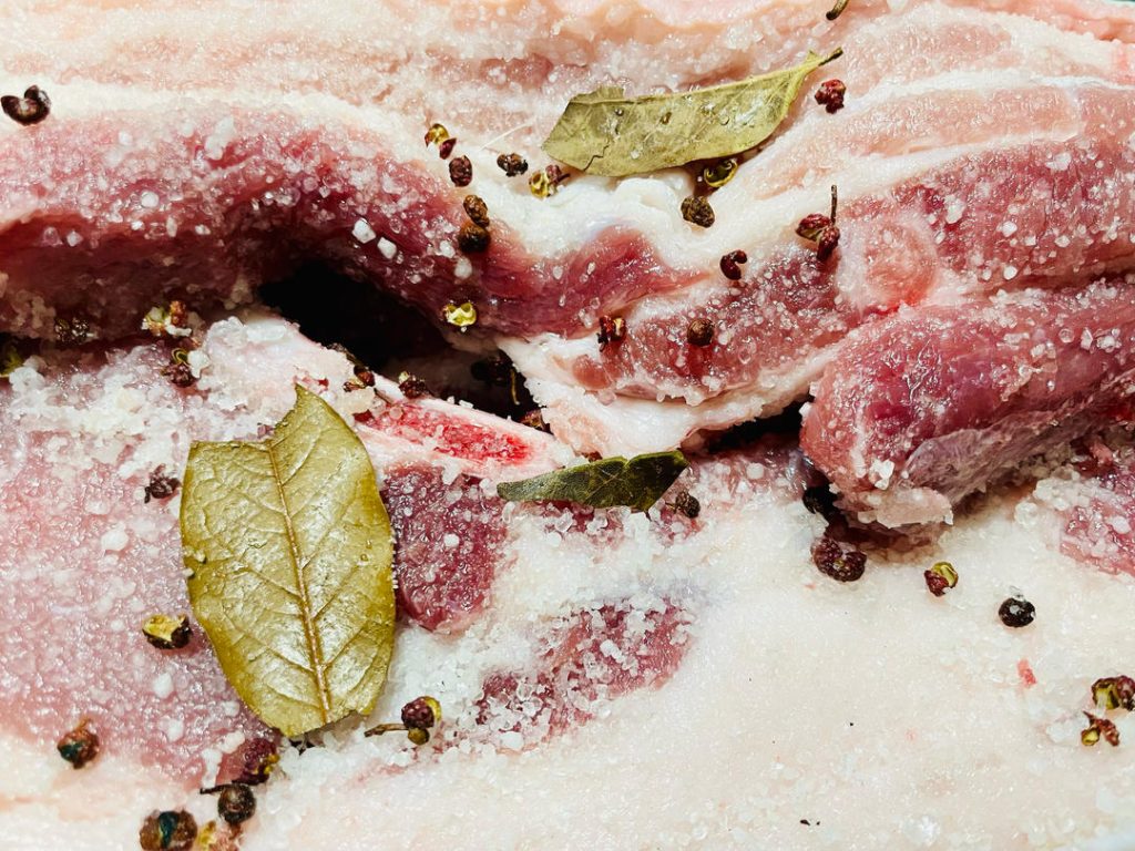 Once the salt mixture is cool, rub it thoroughly over every inch of the pork belly strips. Ensure you get into the crevices and coat the skin. Place the pork in a large bowl or container. Let it cure in a cool place (refrigerator is safest) for 3 to 4 days. Turn the meat once a day to redistribute the juices that will be drawn out.