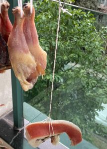 After the curing period, poke a hole in the top of each pork strip and thread kitchen twine through it. Hang the meat outside in a sunny, well-ventilated area. It needs to dry in the sun for 4 to 5 days.