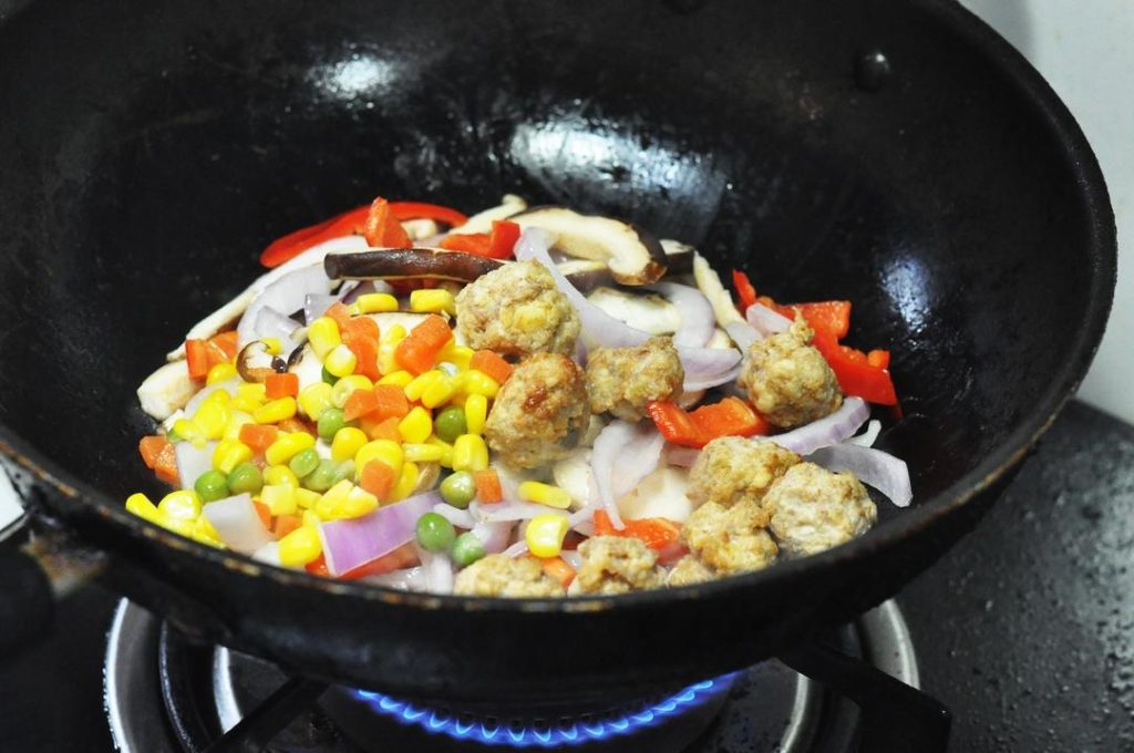 Stir-fry Aromatics and Meat Heat your wok or large skillet over medium-high heat. Add 1 tablespoon of oil. Add the sliced onion, red pepper, corn, and meatballs. Stir-fry for 2-3 minutes until the onions are translucent and fragrant.