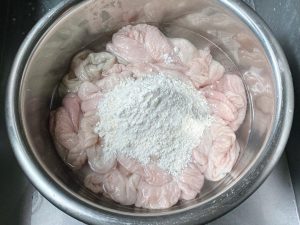 For the third time, add 2 tablespoons of flour and repeat the kneading and rinsing. By now, the exterior should look very clean. Smell it; if a strong odor persists, you can do a fourth flour wash.