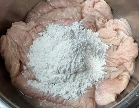 Place the unwashed intestines in your large basin. Add 2 tablespoons of flour. Begin kneading and rubbing the flour into the surface. The flour will clump as it absorbs the thick mucus. If it feels too dry, add a tiny splash of water.