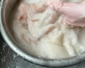 Place the unwashed intestines in your large basin. Add 2 tablespoons of flour. Begin kneading and rubbing the flour into the surface. The flour will clump as it absorbs the thick mucus. If it feels too dry, add a tiny splash of water.