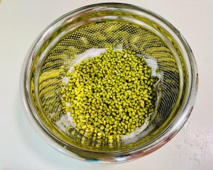 Layer the Beans: Drain the soaked beans and spread them evenly over the wet cloth.