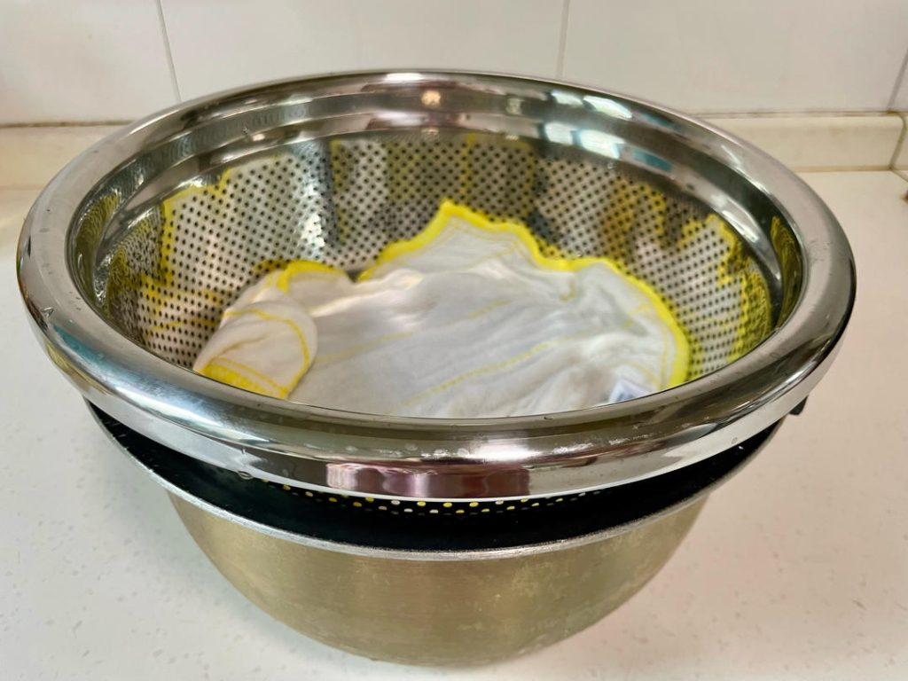 The Drainage Setup: Place the colander inside a larger pot or bowl (an old rice cooker pot works great) to catch dripping water. Crucial: Ensure the bottom of the colander is not touching the drained water.