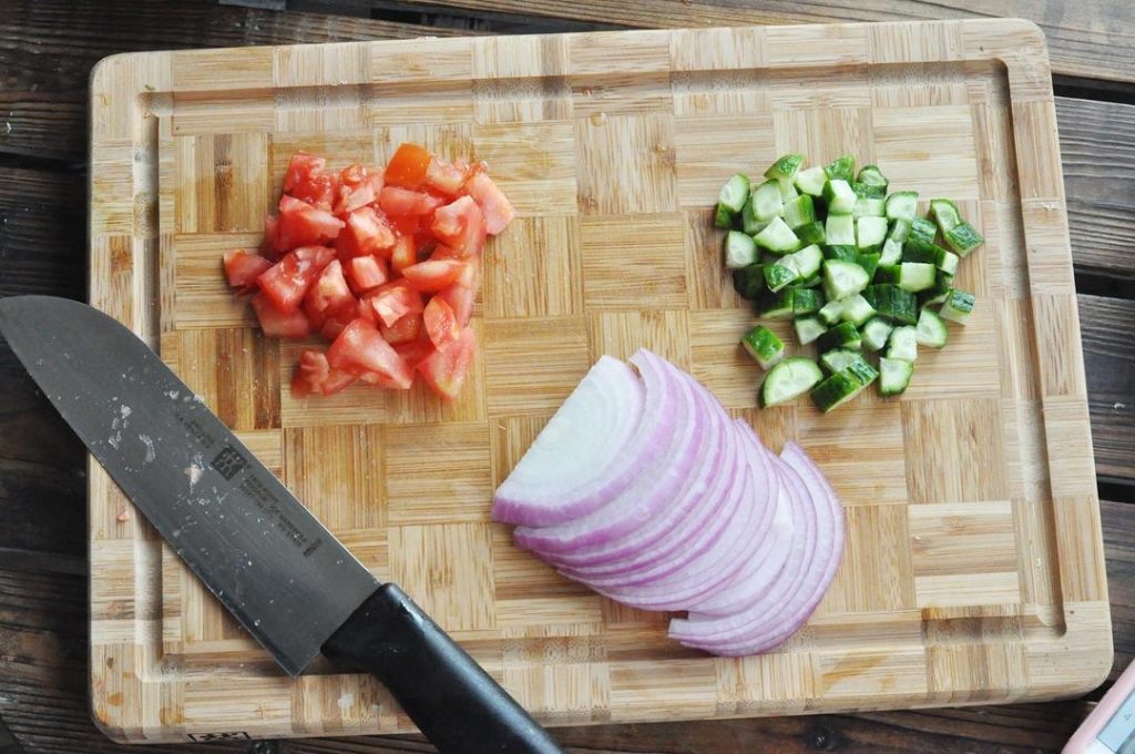 Slice the onion into thin strips. Dice the tomato and cucumber into small cubes (approx. 1cm).