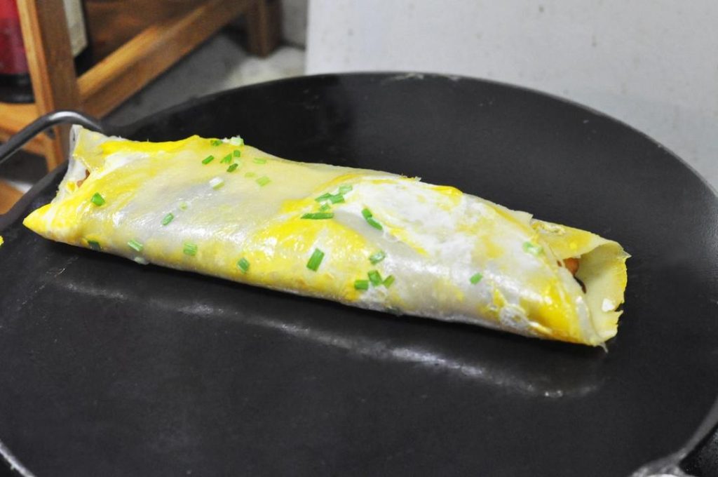 Fold and Serve Fold the sides of the pancake inward over the Youtiao, then fold it in half vertically (like a burrito). Remove from the pan and serve hot!