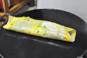 Fold and Serve Fold the sides of the pancake inward over the Youtiao, then fold it in half vertically (like a burrito). Remove from the pan and serve hot!