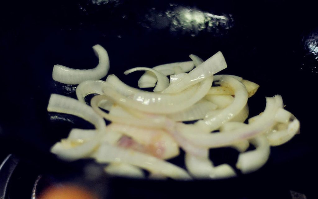 Sauté Aromatics Wipe the wok if needed. Add another tablespoon of oil over medium heat. Add the onion slices and stir-fry until fragrant and slightly translucent.