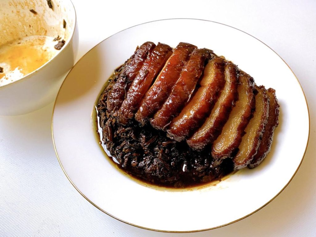 Remove the bowl from the steamer. Place a serving plate upside down over the bowl, and carefully flip them together. Lift the bowl off. If there is excess liquid, pour it into a saucepan, thicken it with a little cornstarch slurry, and pour it over the pork for a glossy finish.