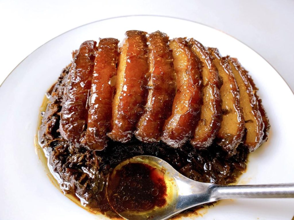 Remove the bowl from the steamer. Place a serving plate upside down over the bowl, and carefully flip them together. Lift the bowl off. If there is excess liquid, pour it into a saucepan, thicken it with a little cornstarch slurry, and pour it over the pork for a glossy finish.