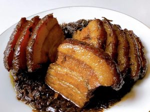 Remove the bowl from the steamer. Place a serving plate upside down over the bowl, and carefully flip them together. Lift the bowl off. If there is excess liquid, pour it into a saucepan, thicken it with a little cornstarch slurry, and pour it over the pork for a glossy finish.