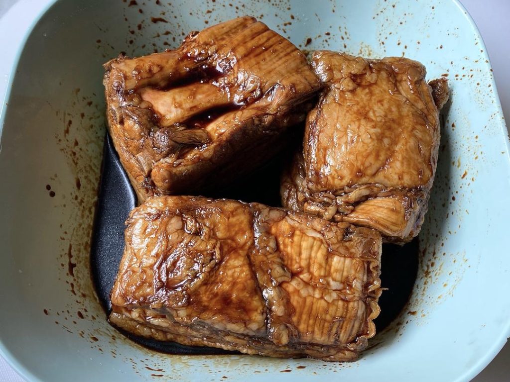 Rub the 2 tbsp of dark soy sauce all over the pork. Place it skin-side down in a shallow dish with the leftover dark soy sauce to soak for 10 minutes. Remove and dry the skin completely.