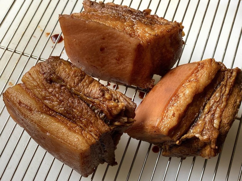 Rub the 2 tbsp of dark soy sauce all over the pork. Place it skin-side down in a shallow dish with the leftover dark soy sauce to soak for 10 minutes. Remove and dry the skin completely.