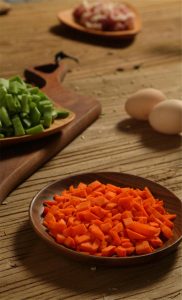 First, dice the green beans (四季豆) and carrots into small cubes. Dice the pork belly (五花肉) into similar-sized cubes. If you are using ground pork, it is ready to go. Crack the eggs into a bowl and beat them well.