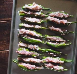 Stuff the Peppers Gently open the slit of a pepper. Using a small butter knife or a teaspoon, stuff the pork mixture inside. Fill it generously, but do not overstuff to the point where the pepper rips open. Smooth out the exposed meat at the slit.