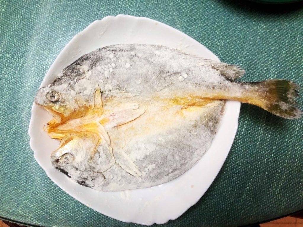 Scatter the flour over the fish, ensuring a thin, even coating on both sides. Shake off any excess.