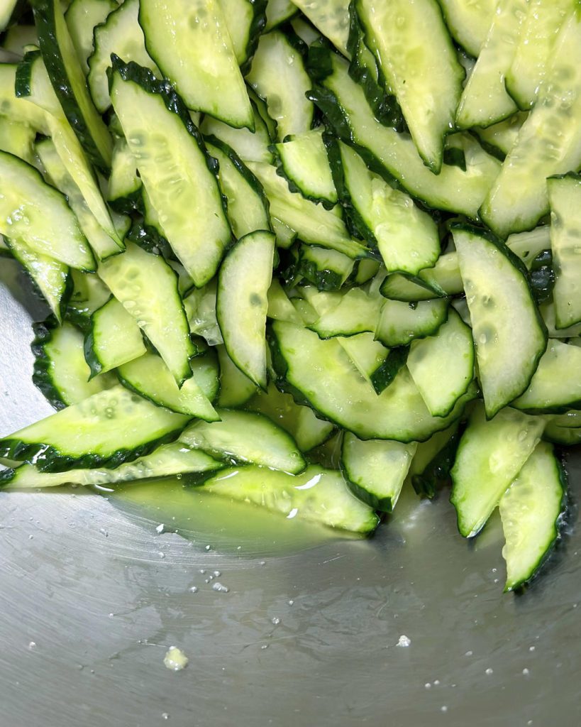 Prep the Cucumber (The Most Important Step) Slice the cucumber in half lengthwise, then cut diagonally into thin slices (approx 1/8 inch thick). Place in a large bowl and toss with 1 tablespoon of salt.