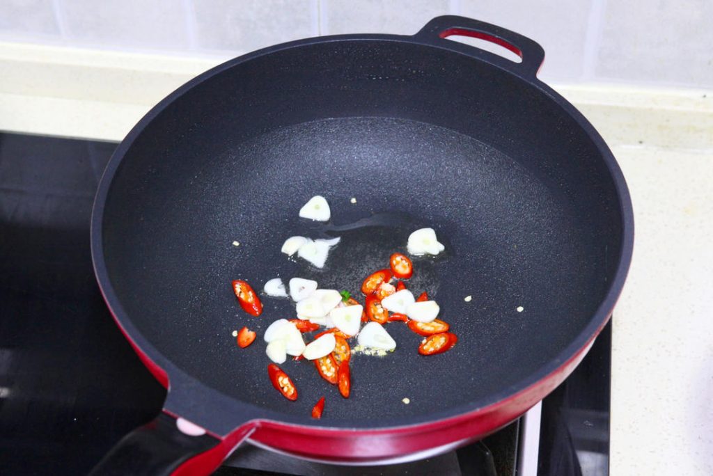 Bloom Aromatics & Fry Cucumber Wipe the wok if needed. Add the remaining 1 tablespoon of oil. Toss in the garlic and chilies, stirring for 10 seconds until fragrant. Add the squeezed cucumber slices.