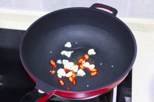 Bloom Aromatics & Fry Cucumber Wipe the wok if needed. Add the remaining 1 tablespoon of oil. Toss in the garlic and chilies, stirring for 10 seconds until fragrant. Add the squeezed cucumber slices.