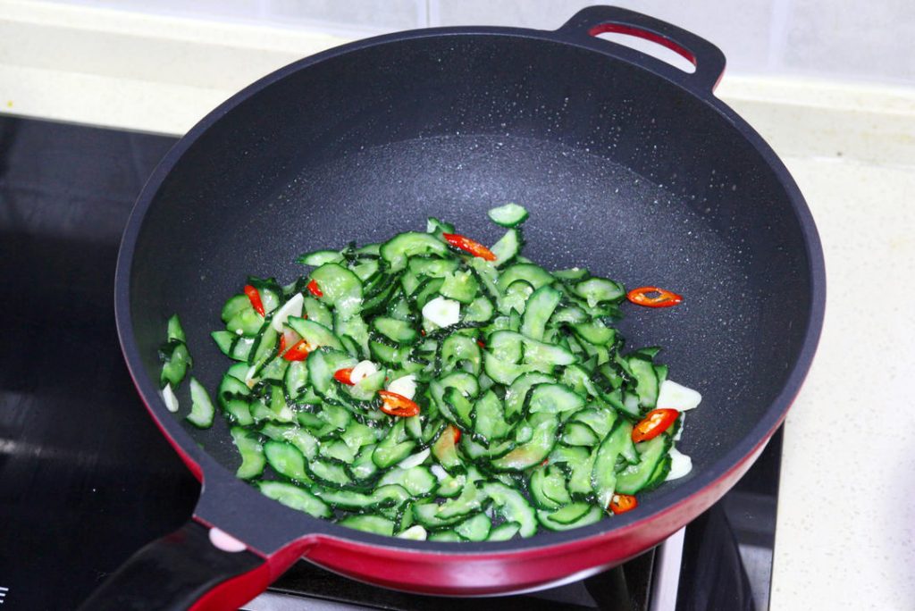 Bloom Aromatics & Fry Cucumber Wipe the wok if needed. Add the remaining 1 tablespoon of oil. Toss in the garlic and chilies, stirring for 10 seconds until fragrant. Add the squeezed cucumber slices.