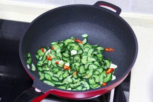 Bloom Aromatics & Fry Cucumber Wipe the wok if needed. Add the remaining 1 tablespoon of oil. Toss in the garlic and chilies, stirring for 10 seconds until fragrant. Add the squeezed cucumber slices.