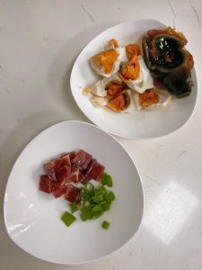 Prep the ingredients: Slice the baby cabbage lengthwise into quarters. Rinse thoroughly and drain. Peel and roughly chop the salted duck eggs and century egg. Dice the ham and chop the scallions.