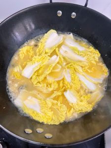 Braise the Cabbage: Gently lay the quartered baby cabbages into the broth. They should be mostly submerged. Cover with a lid.