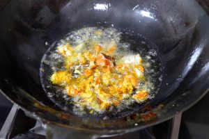 Fry the Roe (The "Explosion") Lower the heat to low-medium. Gently slide in the crab roe (and paste).